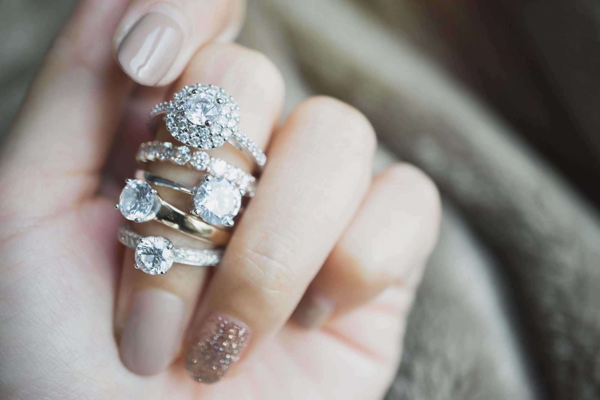 Many engagement rings on a woman's finger represent visual comparisons of diamond shapes in engagement rings.