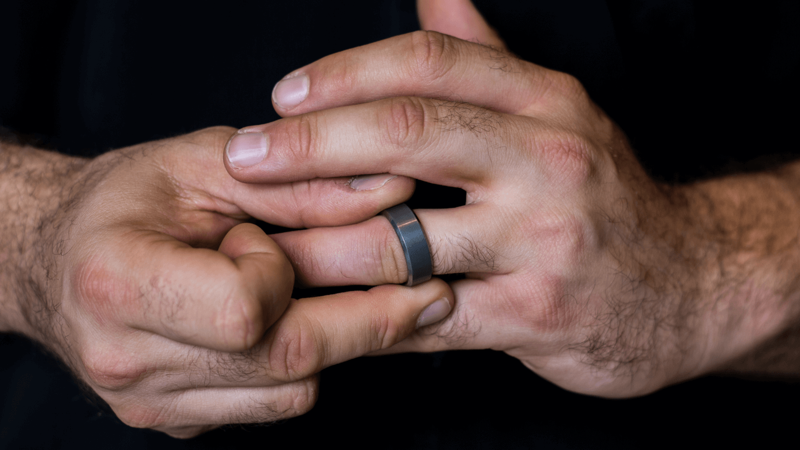 Close up of a man's hand wearing an engagement or wedding ring