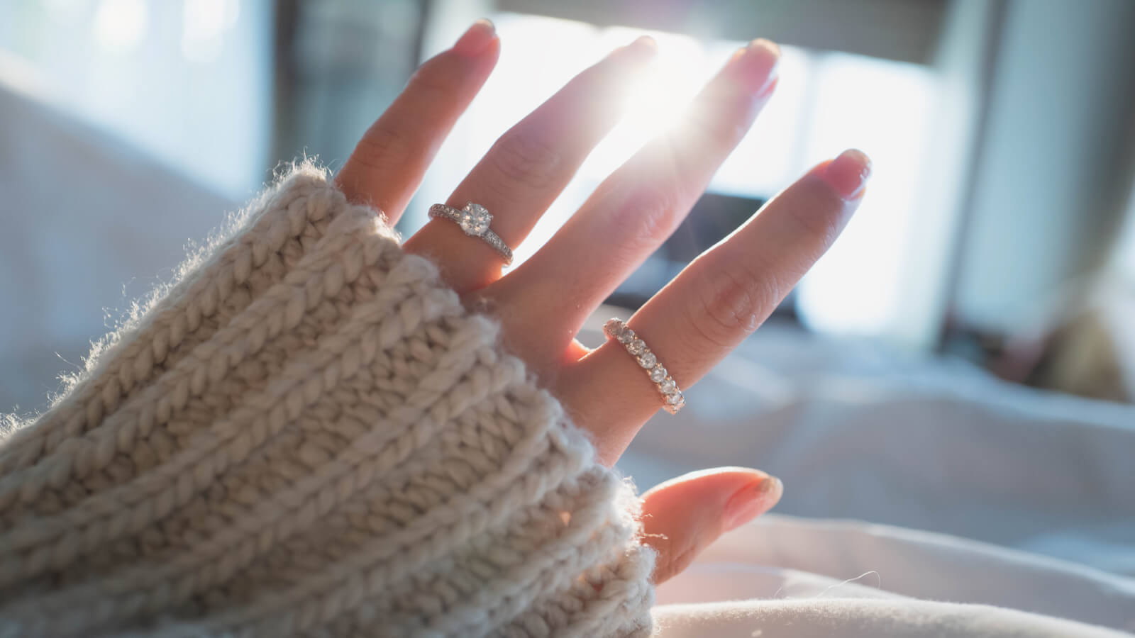 Close up of a woman's hand wearing an engagement ring and or a promise ring 