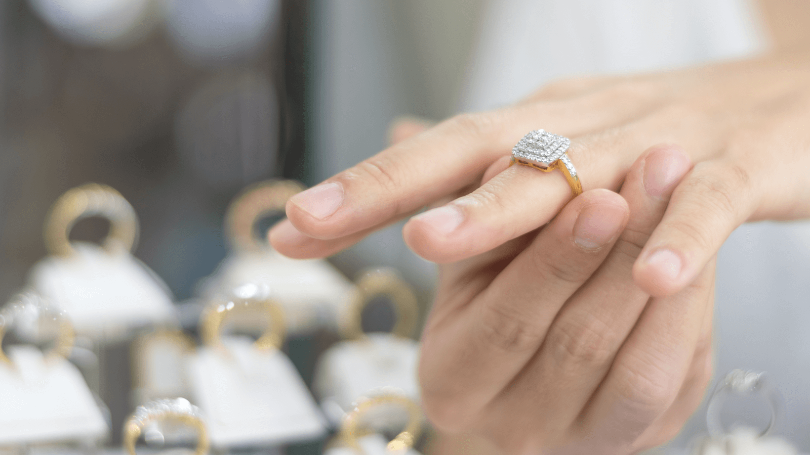 Hand of woman customer trying diamond gold ring for wedding, engagement ring shopping concept