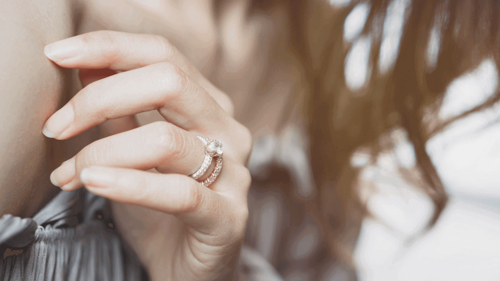 Close up of a woman's hands wearing stacked wedding ring and engagement ring
