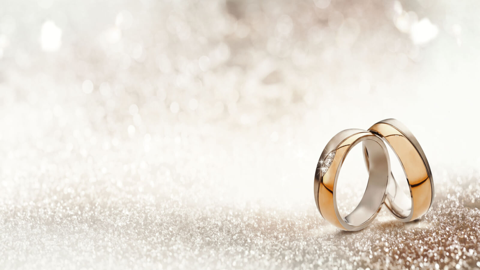 two wedding rings on a sparkly background
