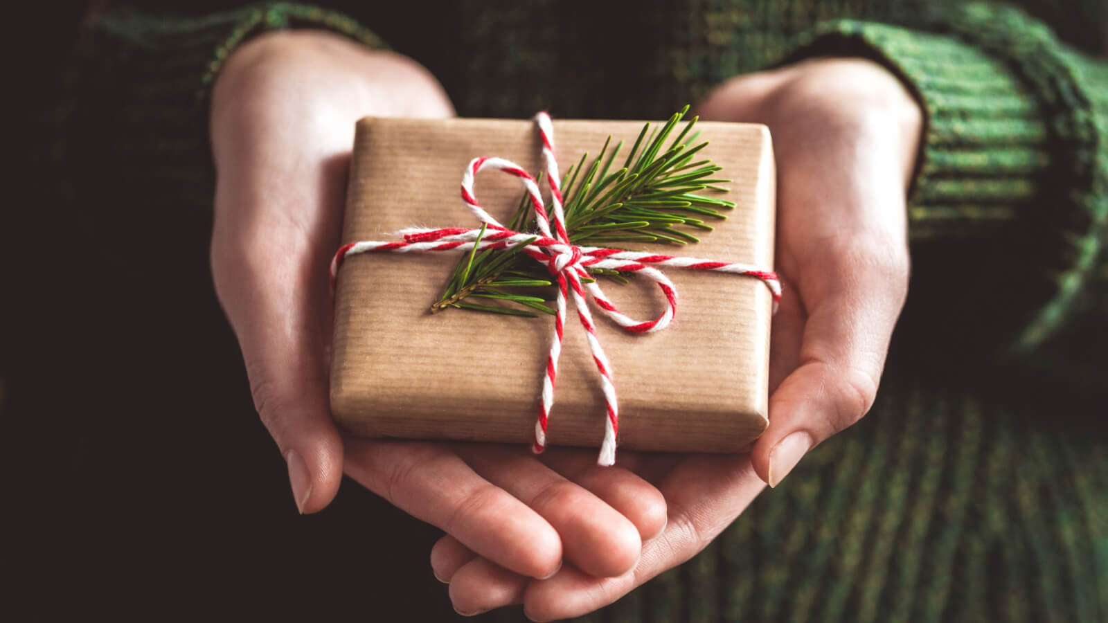 woman's hands holding small wrapped gift