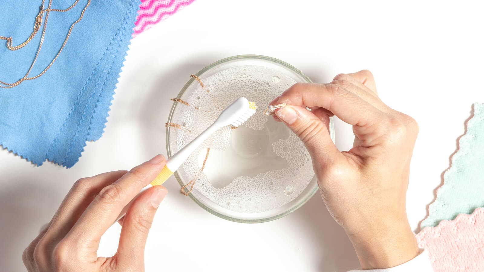 cleaning ring in bowl of soapy water with toothbrush