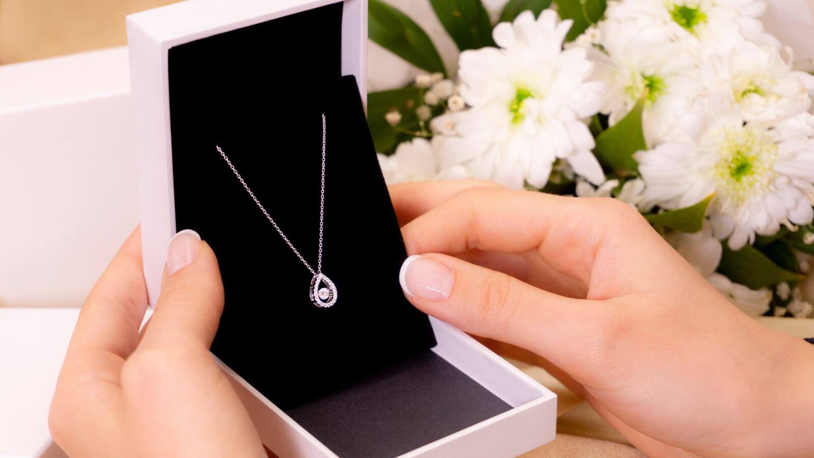 hand with jewelry gift box with necklace 